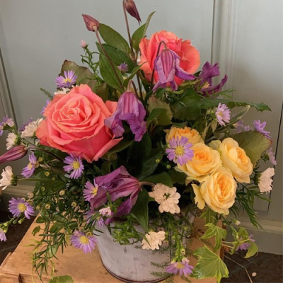 Out in the Woods - A charming container arrangement. Includes a mix of pink, yellow and purple flowers with complimentary foliage. Hand delivered with care in and around Dereham by Bright and Beautiful.