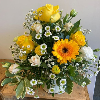 Smiles All Round - A beautiful container arrangement. Includes a mix of yellow, white and green flowers with complimentary foliage. Hand delivered with care in and around Dereham by Bright and Beautiful.