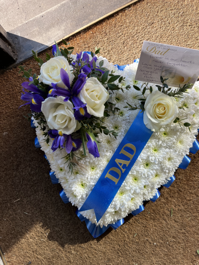 Blue and white heart - Heart tribute with a white base, blue ribbon and blue and white posy.