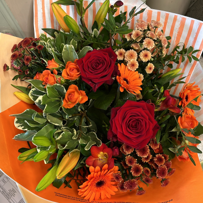 Autumn rainbow - Autumn rainbow of shades hand tied in a box with water including roses, lilies, gerbera, chrysanthemums, and  freesia.